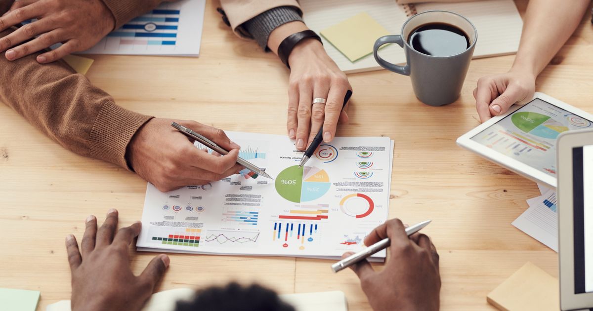 Business professionals reviewing financial projections and loan documents at a conference table