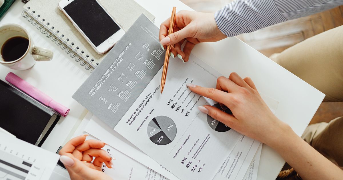 Business owner reviewing financial documents and sales reports at a modern office desk